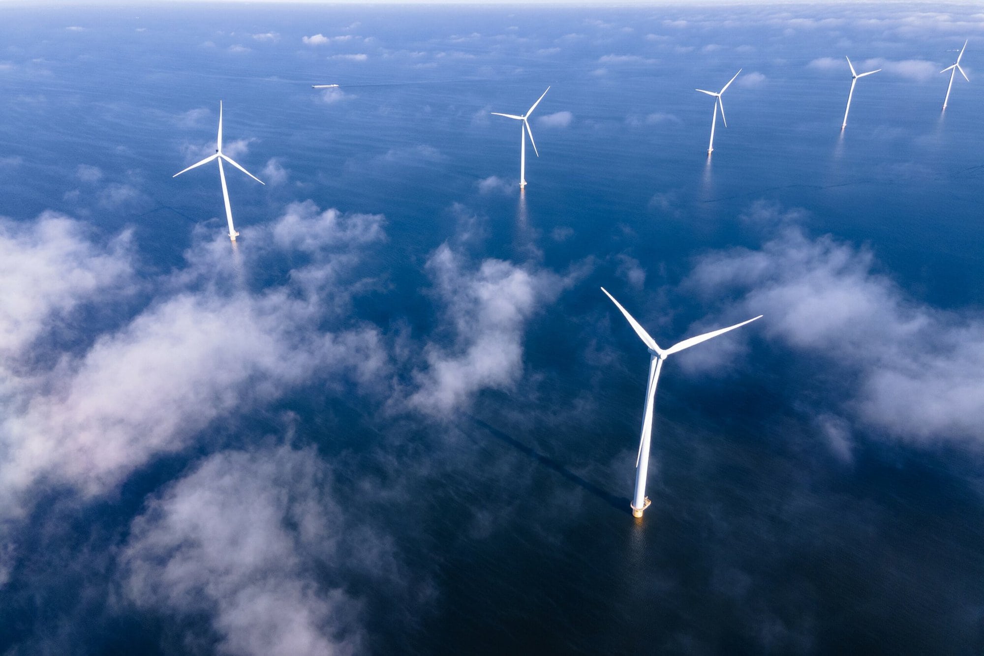 Offshore Windmill Park With Clouds And A Blue Sky, Windmill Park In The Ocean Aerial View With Wind